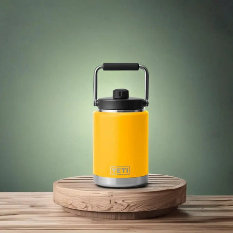 Yellow Rambler Half Gallon Jug With MagCap Vacuum Insulated Stainless Steel No Sweat Design on round wooden base.