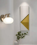 Smooth Modern Wall Sconce With White Glass Shade And Heavy Duty Metal Geometric Design For Kitchen Bedroom Hallway, lit wall fixture.
