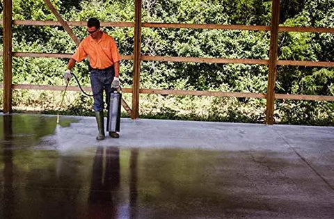 Man applying Tough As Nails Penetrating Concrete Sealer For Driveways And Retaining Walls Breathable Moisture Shield on a concrete slab.