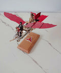Retro model of Stirling Air Ship with red wings, DIY metal flying machine on a wooden base for steampunk fans.