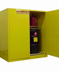 Built Tough Flammable Drum Storage Cabinet For Workshop Or Garage Holds Two Barrels With Self Closing Double Doors Adjustable Shelf Smooth Rolling Casters OSHA NFPA Certified Bright Yellow, open with black drum and red can inside.