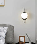 Upgrade Your Vibe With Sleek Brass Wall Sconces Featuring Handcrafted White Glass Globe Shades Ideal For Modern Farmhouse And Bedroom Lighting E27 Socket. Single modern sconce with white globe on the wall.