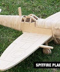 Wooden model of a Spitfire plane created using a CNC router, displayed on grass.