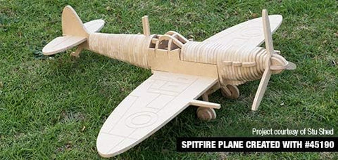 Wooden model of a Spitfire plane created using a CNC router, displayed on grass.