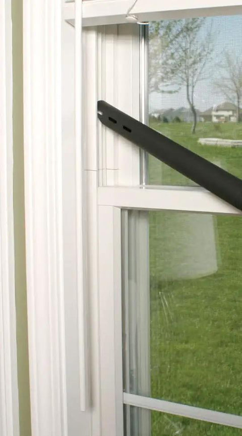Black extension hose of the Upright and Canister Vacuum Extension Hose and Attachment Kit near a window frame.