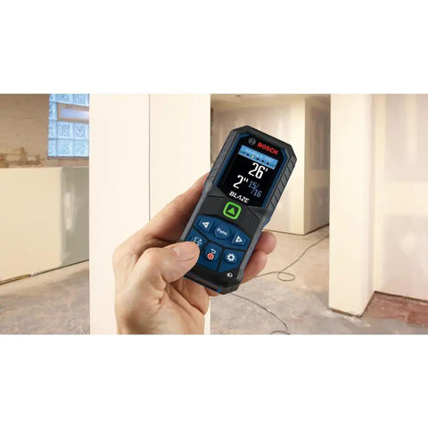 Person holding Blaze Green Beam Laser Measure Up To 165 Feet With Real Time Distance Reading, bright screen readout.
