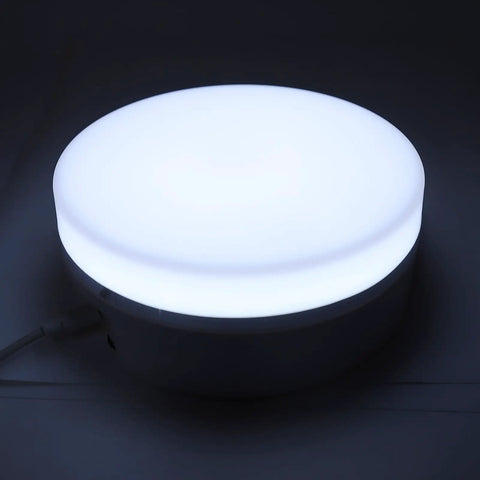 Awesome 360 Rotating Display Stand With Adjustable LED Lights And 11 Pounds Load Capacity, round LED light on smooth surface.