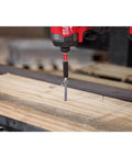 Milwaukee Shockwave impact driver driving a screw into a wooden plank