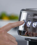 Close-up of a hand pressing buttons on the Damson Blue Kickass Espresso Coffee Maker Featuring Auto Milk Frother Quick Heat Technology.