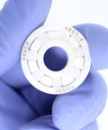 Front view of a white 608 zirconia full-ceramic bearing held by gloved hand, showing outer race and ceramic balls.