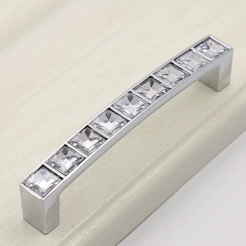 Close-up of Six Pack U Shape Crystal Glass Drawer Pull Knob with shiny silver handle and zinc alloy base on cabinet.