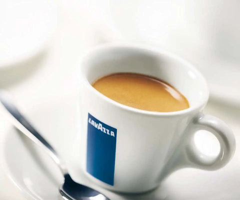 Close-up of a white cup with espresso on a saucer with a spoon