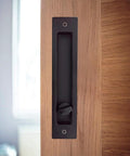 Hidden Pocket Door Lock Hardware With Keys, Recessed Matte Black Door Handle For Sliding Pocket Doors, shown installed on wood door