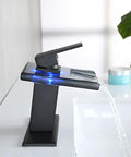LED Temperature Sensing Slick Matte Black Bathroom Sink Faucet With Open Glass Spout Waterfall Flow Single Hole Mount Includes Metal Pop Up Drain And Two Water Supply Lines Color Changing Lights From Blue To Green To Red For Cold To Hot Water showing blue light