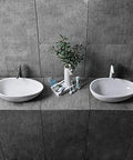 Real Deal White Oval Vessel Sink Built Tough From Dense Artificial Stone For Quick Countertop Installation With A Slick Finish. Two sinks on gray tiles.