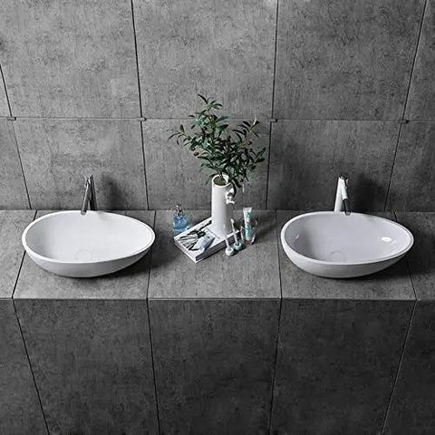 Real Deal White Oval Vessel Sink Built Tough From Dense Artificial Stone For Quick Countertop Installation With A Slick Finish. Two sinks on gray tiles.
