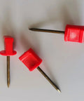 Three red-headed nails from 20Pack Archery Target Pins Heavy Duty Manganese Steel Nails With Plastic Heads For Holding Target Faces And Paper