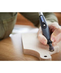 Dremel flex shaft rotary tool with comfort grip engraving a wooden piece in close-up view