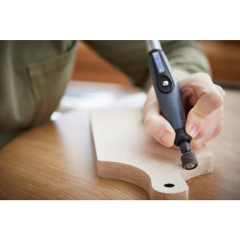 Dremel flex shaft rotary tool with comfort grip engraving a wooden piece in close-up view