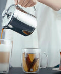 Aqua Turkish Teapot Set In Eighteen Ten Stainless Steel With Double French Press in use pouring coffee into glass mugs.