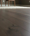 Pro Grade Reactive Water Based VOC Free Wood Stain For Pine on dark finished wood flooring in a modern interior setting.