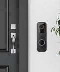 Black Doorbell Back Plate Replacement For Video Doorbell Mounting Systems Kit installed on a white wall by a door.