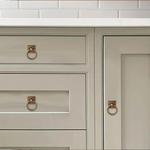 10 Pack 1.9 Inch Ring Cabinet Knobs With Vintage Antique Brass Backplates For Drawers Dressers Kitchen Cabinets Closets Wardrobes DIY Friendly Heavy Duty Zinc Alloy Hardware installed on light gray cabinet doors and drawers.