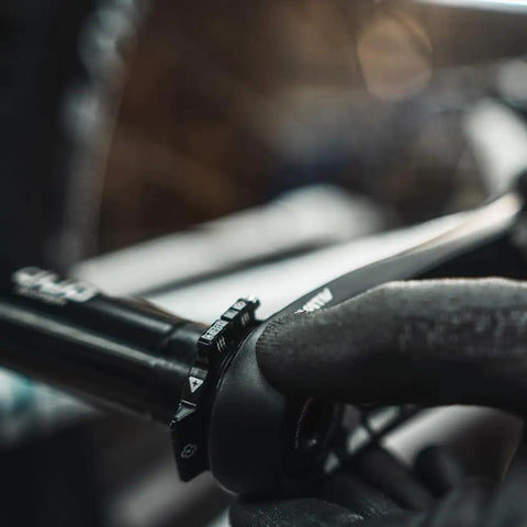 Close-up of hand adjusting crank preload ring for bottom bracket alignment on a bike, using durable aluminum tightening ring in black.