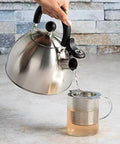 Whistling Stovetop Tea Kettle With Food Grade Stainless Steel, 1.5 Quart Capacity, Boils Fast, No Waiting, Cool Touch Folding Handle in use