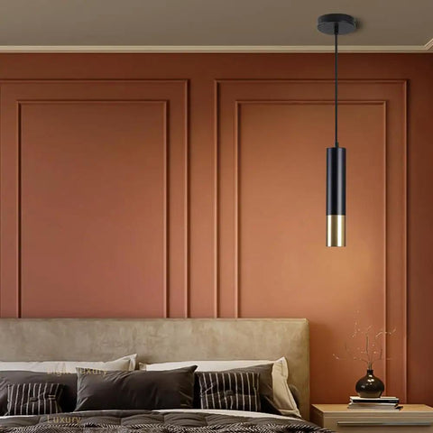 Modern single pendant light fixture above bedside table in a minimalist bedroom
