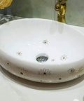 Slick Ceramic Oval Vessel Sink For Modern Bathroom Counters Smooth Glazed Finish with floral design and 12-liter capacity.