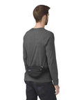 Man wearing Fifth Avenue Fanny Pack Crossbody Bag For Women And Men, Durable Go-To Waist Bag with Adjustable Belt, Black, rear view