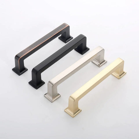 Four metal cabinet handles in black, silver, gold, and copper finishes, showcasing modern design and durable construction.