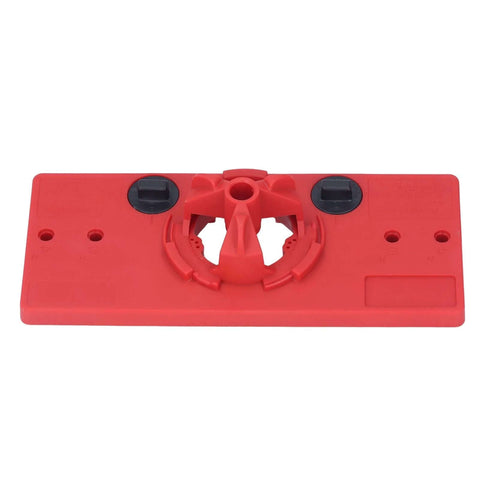 Red plastic woodworking hinge drilling jig base with central bore and two black adjustment dials