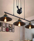 Fresh Vintage Industrial Billiard Chandelier Features Easily Adjustable Pulley Lift System In Classic Black Metal three light pendant lamp above dining table.