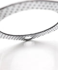 Exhaust gasket with perforated steel outer ring and white graphite center.
