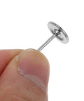 Closeup of sleek stainless steel upholstery tack held in finger for DIY projects. Kick Up Your DIY Game With Sleek Stainless Steel Upholstery Tacks Delivered Straight To Your Door With Top Shelf Decorative Furniture Nails Designed For Easy Sofa And Headboard Projects.