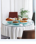 Super Smooth Tempered Glass Lazy Susan For Dining Table 360 Degrees Turntable with food on a round glass serving tray.