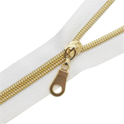 Close-up of Size Five Gold Nylon Coil Zipper With White Tape By The Yard, features 10 Yards Of Continuous Zip and 25 Gold Pulls