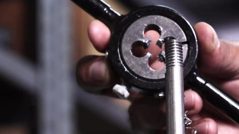 Close-up of 1-3/4-10 UNC Round Adjustable Die in use, threading metal rod, showcasing High Speed Steel HSS and bright finish.