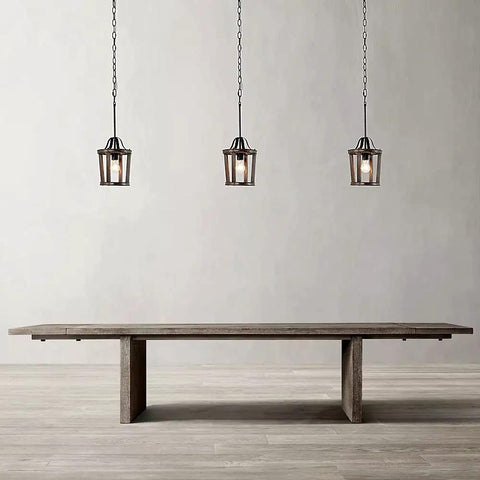 Three Dope Farmhouse Oak Wood Island Pendant Light With Bronze Finish hanging above wooden table in minimalistic room.