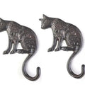 Heavy Duty Cast Iron Cat Wall Hooks Two Pack Featuring A Totally Badass Antique Dark Rust Finish Perfect For Holding Coats Keys And Furry Pet Leashes While Adding Killer Vintage Country Vibes To Your Space, showcasing two cat-shaped hooks.