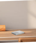 Folded white napkins on a wooden table with a light wall background
