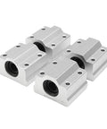 Set of four aluminum linear-rail bearing blocks with mounting holes, front-angle view