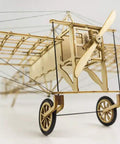Close-up of DIY Balsa Wood Airplane Kit For Adults Dope Laser Cut Bleriot Style Model Plane showing wheels and propeller