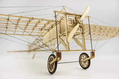 Close-up of DIY Balsa Wood Airplane Kit For Adults Dope Laser Cut Bleriot Style Model Plane showing wheels and propeller