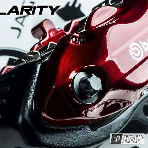 Front view of red automotive wheel component with high-gloss clear top coat; Prismatic Powders Clear Vision branding visible.
