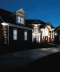 Large house exterior illuminated at night, showcasing Two Light Hammered Glass Outdoor Hanging Lantern Textured Black Traditional Style Porch Light