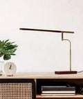 Barrett LED Desk Lamp with Dope Adjustable Walnut Wood Shade on modern desk, sleek design for home office or study space.