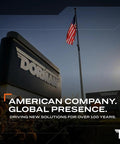 Dorman company sign and American flag, text "American Company. Global Presence. Driving New Solutions For Over 100 Years."